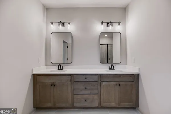 a bathroom with a double vanity sink mirror and shower