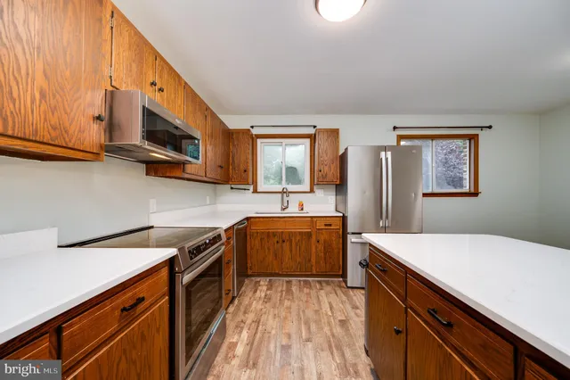 a kitchen with stainless steel appliances a sink stove and cabinets