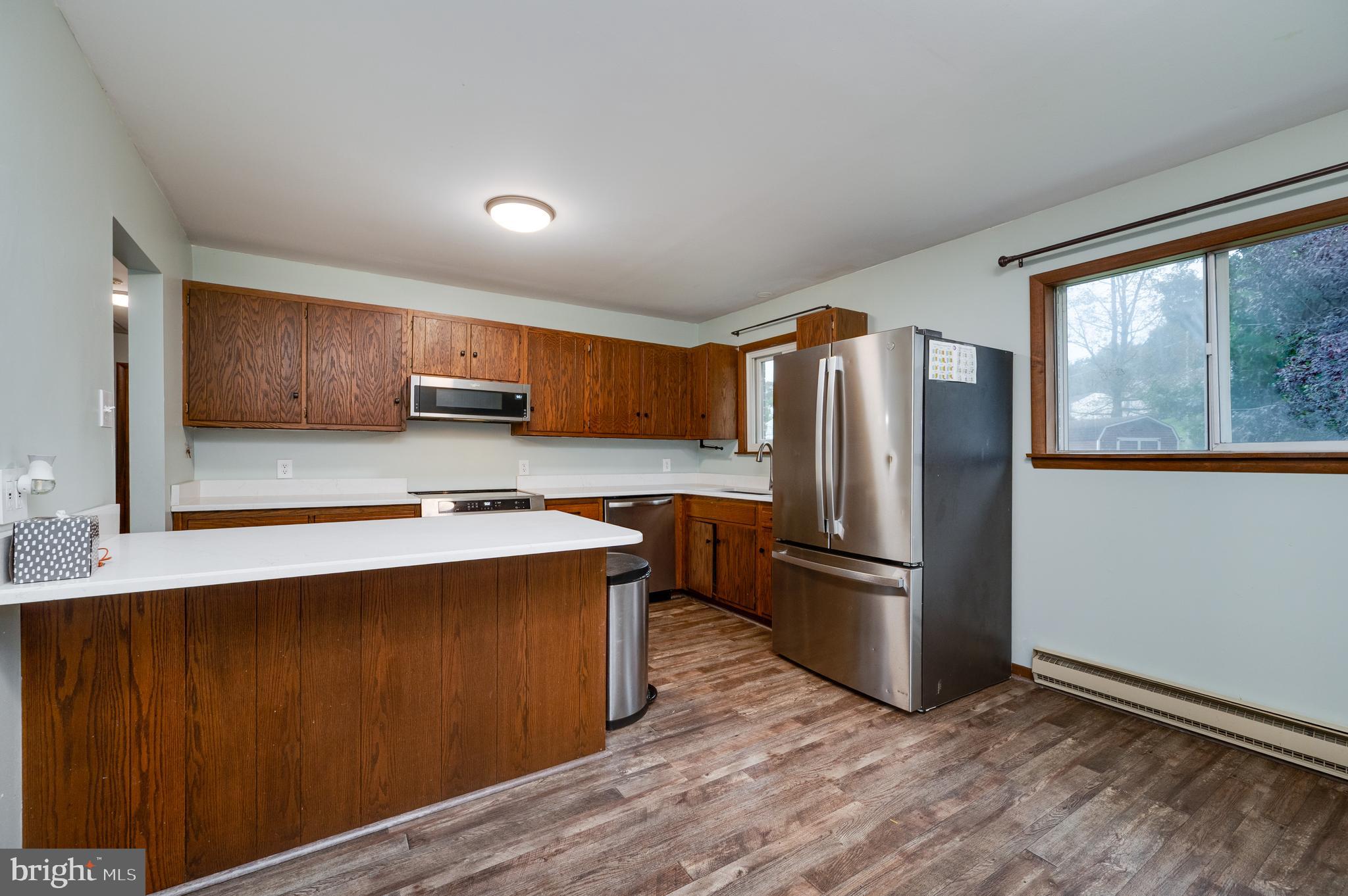1029 Crestview Avenue Reading, PA 19607 - Photo 13 of 44 a kitchen with stainless steel appliances granite countertop a refrigerator a sink dishwasher a stove with wooden cabinets and wooden floor