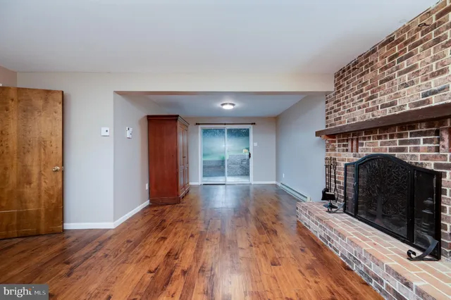 a view of empty room with wooden floor and fireplace
