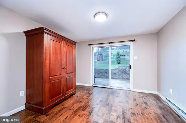 an empty room with wooden floor and sliding door