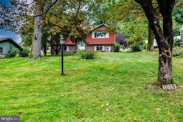 a sign board with a house in the background