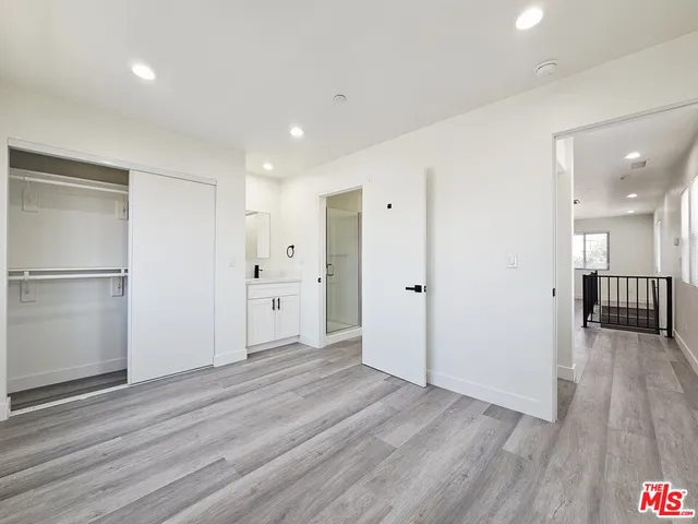 a view of a big room with wooden floor and windows