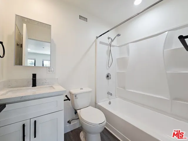 a bathroom with a sink toilet vanity and shower