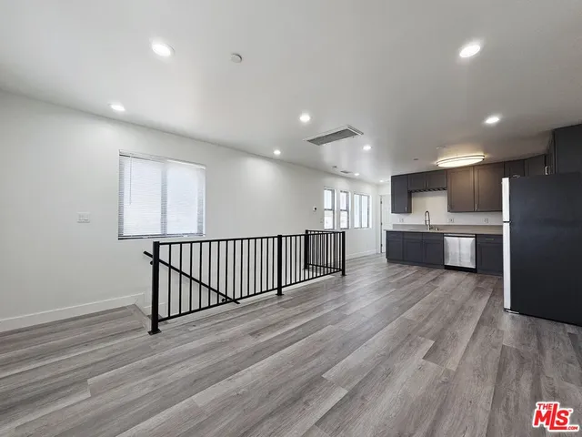 a view of a big room with wooden floor and windows