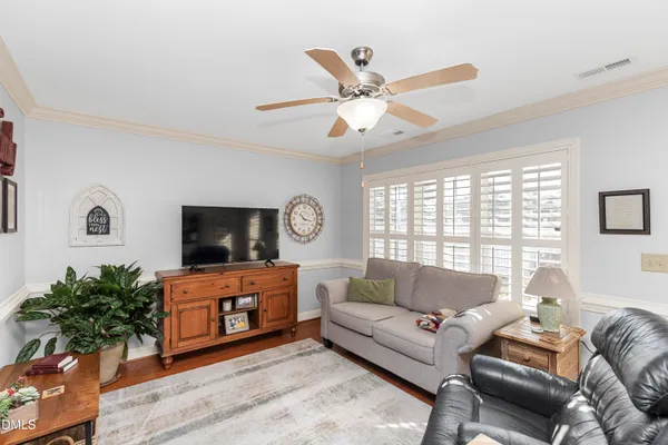 a living room with furniture a flat screen tv and a large window
