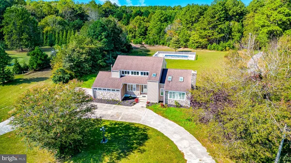 an aerial view of a house with swimming pool and garden