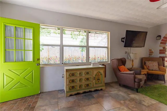 a living room with furniture a flat screen tv and a floor to ceiling window