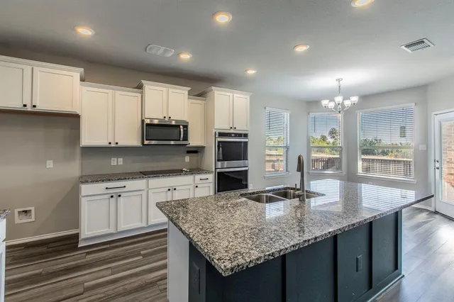 an open kitchen with wooden floors and kitchen view