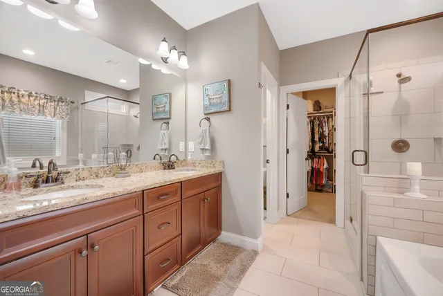 a spacious bathroom with a granite countertop sink mirror and shower