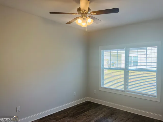 an empty room with a window and a fan