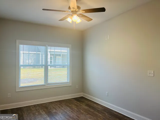 an empty room with a window and a fan