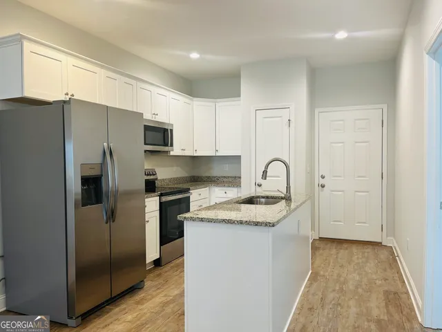 a kitchen with stainless steel appliances granite countertop a refrigerator and a stove top oven