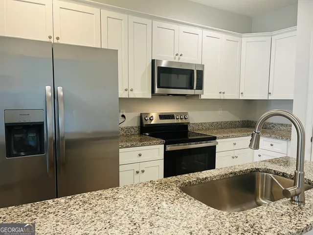 a kitchen with a sink stove and refrigerator