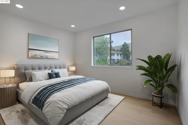 a bedroom with a large bed and a potted plant