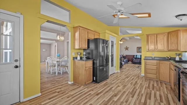 a kitchen with refrigerator a stove and wooden floor