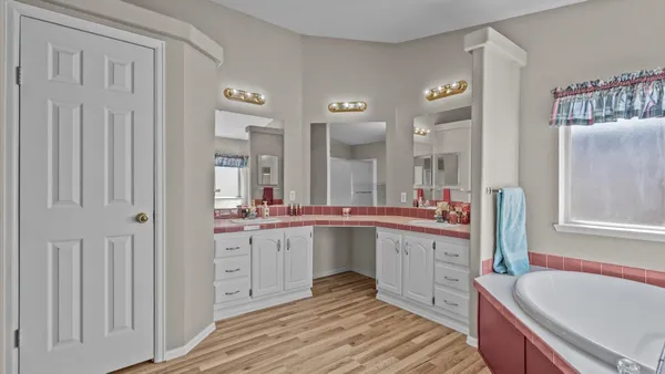 a large white kitchen with a sink and dishwasher with white cabinets