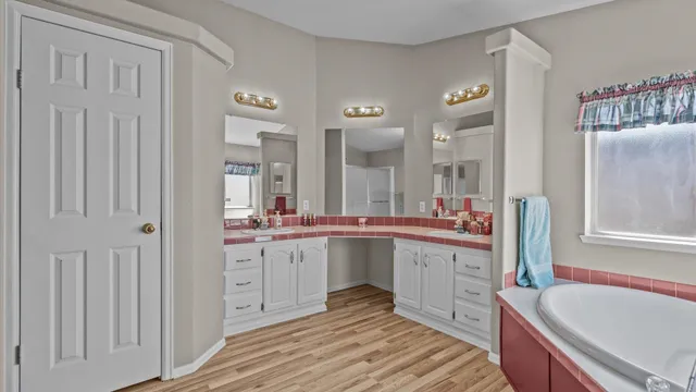 a large white kitchen with a sink and dishwasher with white cabinets