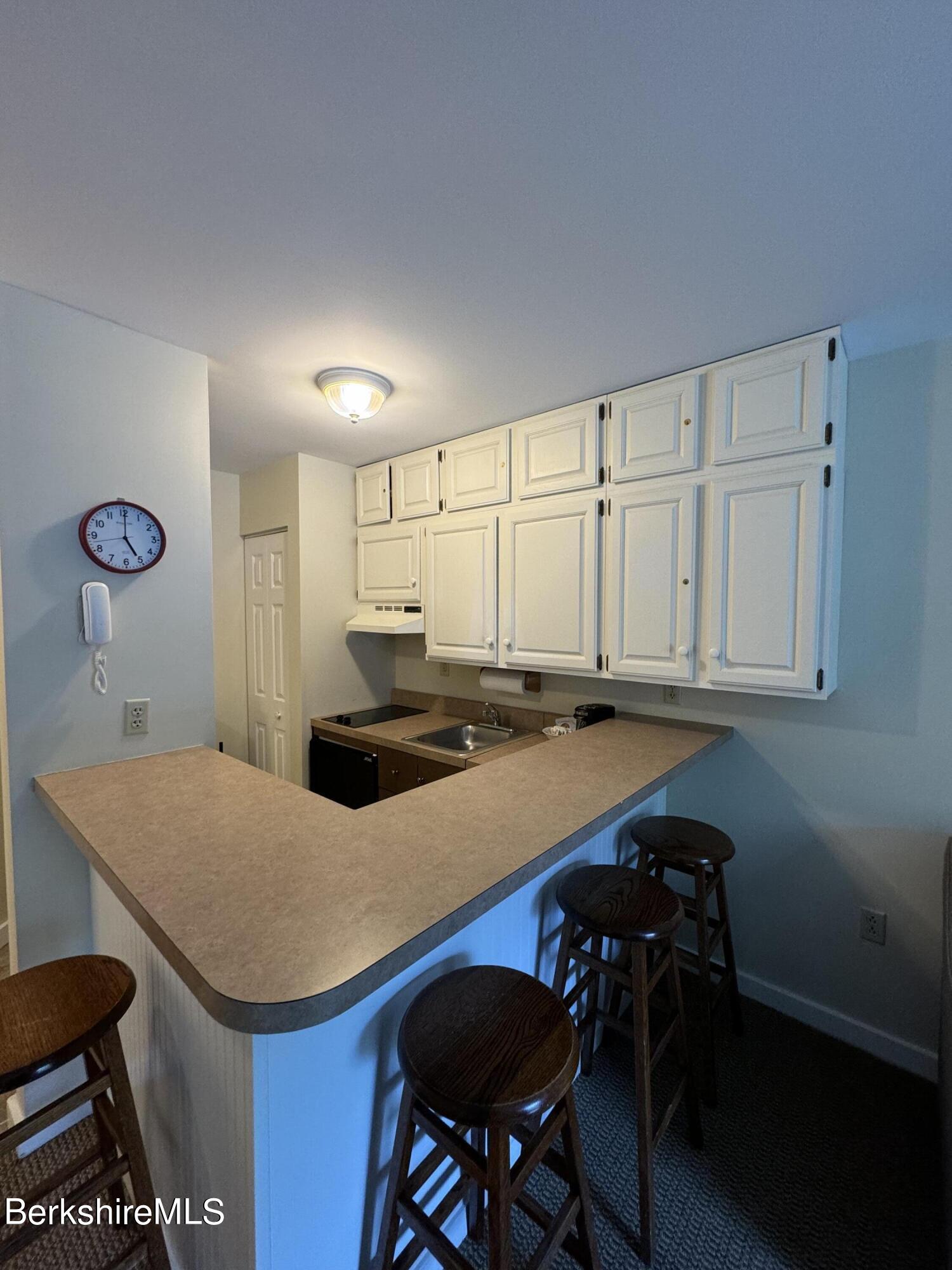 37 Corey Road, Unit 212 Hancock, MA 01237 - Photo 14 of 19 a kitchen with a table chairs and white cabinets