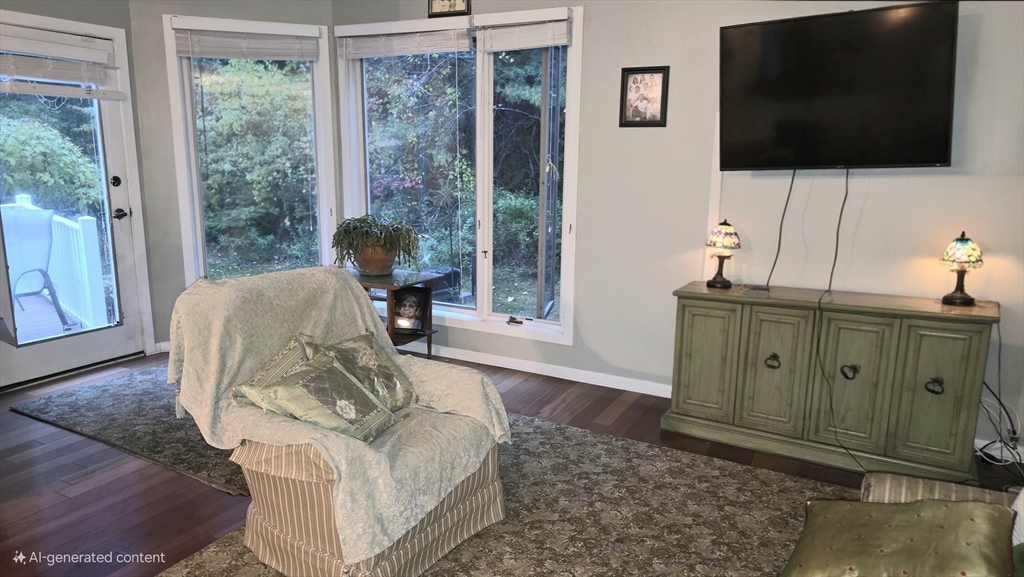 61 Southview Drive, Unit 61 Southwick, MA 01077 - Photo 9 of 28 a living room with furniture a flat screen tv and a floor to ceiling window