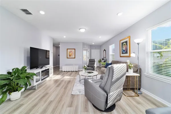a living room with furniture a flat screen tv and a large window