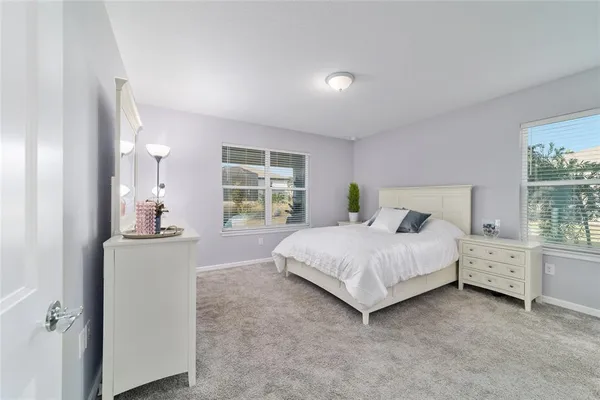 a spacious bedroom with a bed and a window