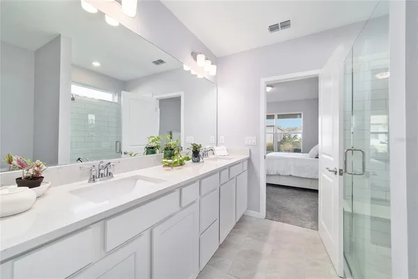 a en suite bathroom with double vanity a sink and shower