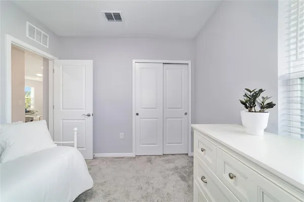 a bedroom with a white bed and a dresser