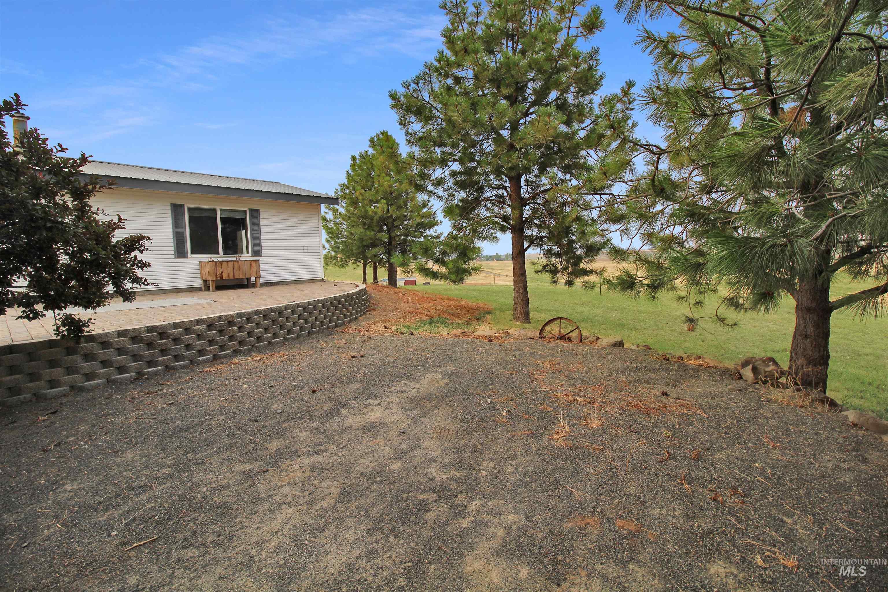2469 Hague Road Midvale, ID 83645 - Photo 3 of 50 White siding exterior with a metal roof and a prominent window featuring dark shutters