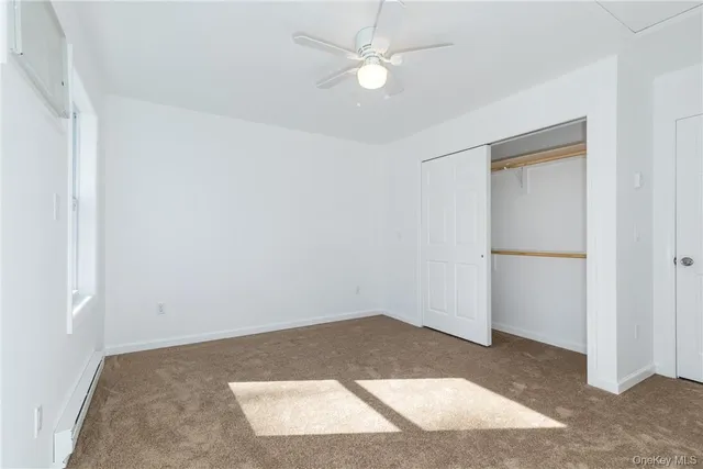 an empty room with a ceiling fan and a window