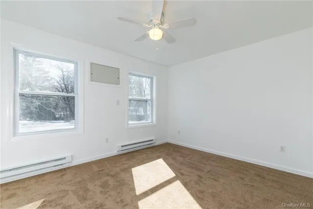an empty room with windows and fan