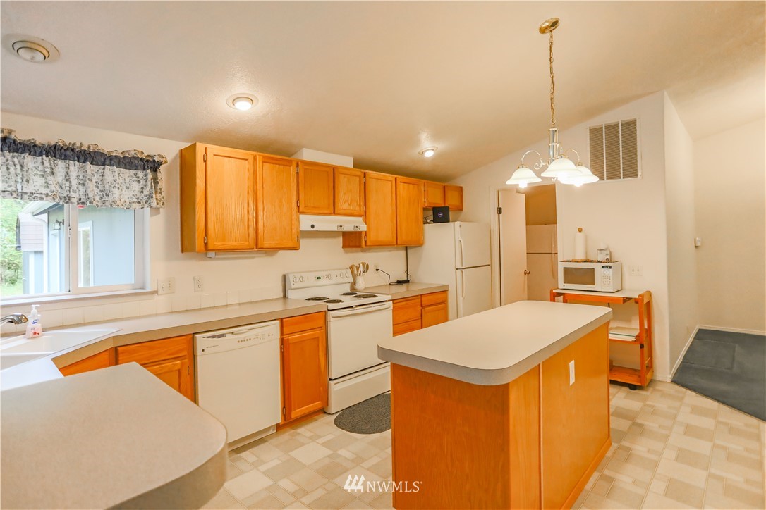1763 Bunker Creek Road Chehalis, WA 98532 - Photo 6 of 40 a large kitchen with kitchen island a sink a stove a refrigerator a counter top space and living room view