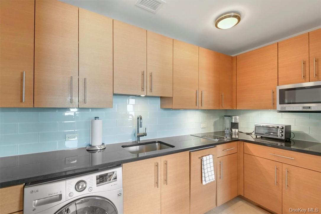 1 Renaissance Square, Unit 9D White Plains, NY 10601 - Photo 4 of 17 a kitchen with granite countertop a sink a stove and cabinets