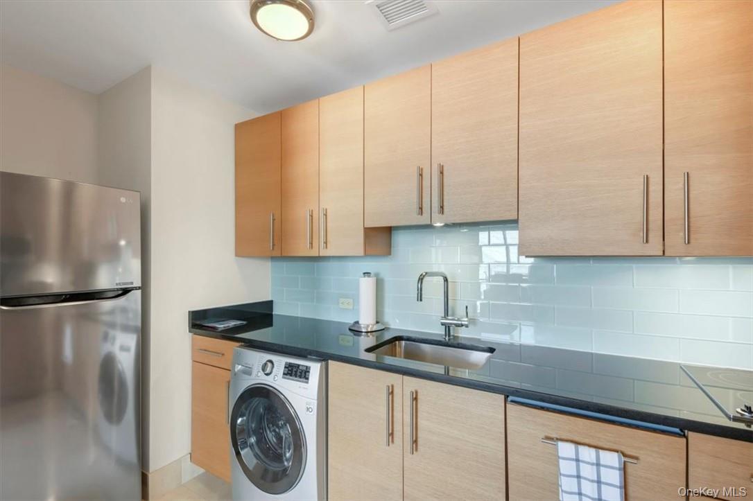 1 Renaissance Square, Unit 9D White Plains, NY 10601 - Photo 5 of 17 a kitchen with stainless steel appliances granite countertop a sink a refrigerator and cabinets