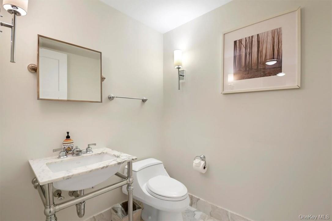 1 Renaissance Square, Unit 9D White Plains, NY 10601 - Photo 6 of 17 a bathroom with a toilet a sink and mirror