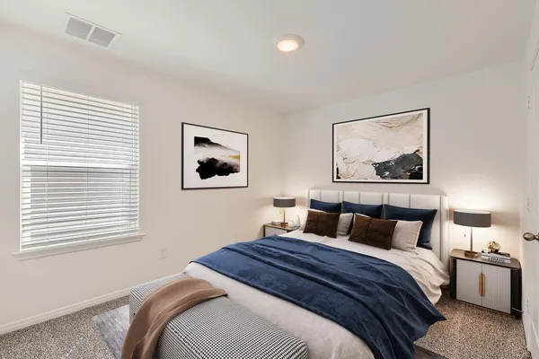 a bedroom with a bed and painting on the wall