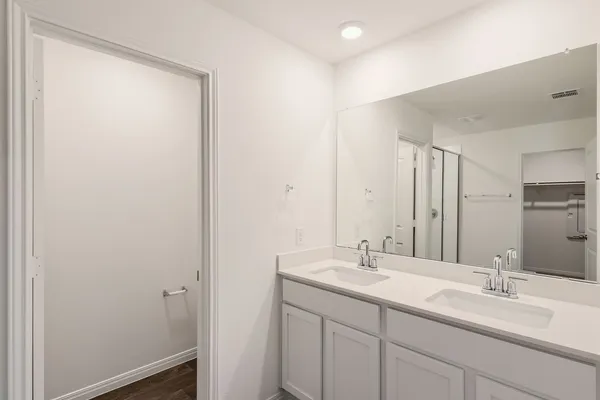 a bathroom with a double vanity sink and a mirror
