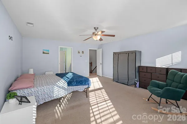 a bedroom with a bed chandelier and a couch