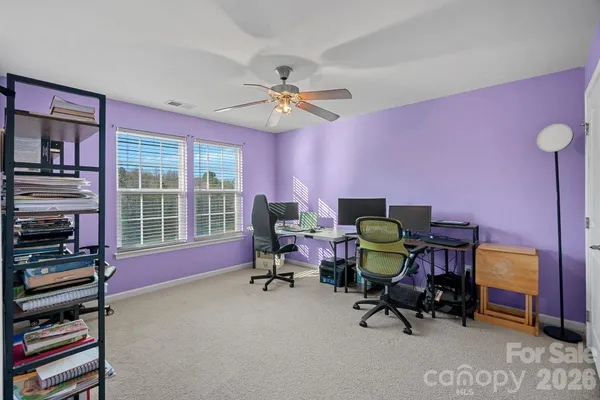 a view of a workspace with furniture and a window