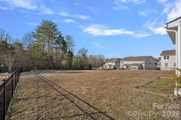 a view of a dry yard with wooden fence