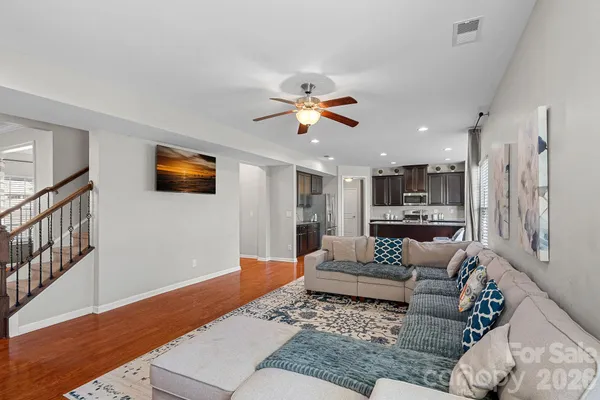a living room with furniture and a view of kitchen