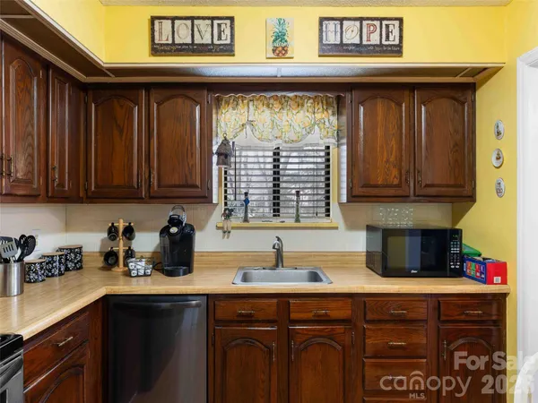 a kitchen with stainless steel appliances granite countertop a sink dishwasher and cabinets with wooden floor