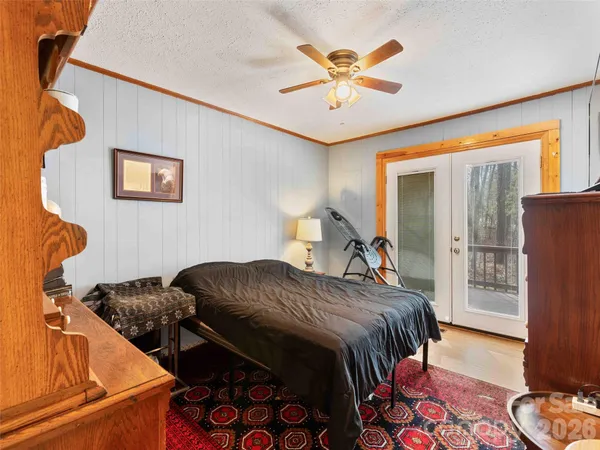 a bedroom with bed and wooden floor