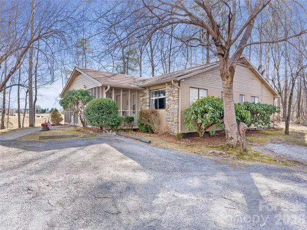 a view of a house with a yard and large tree