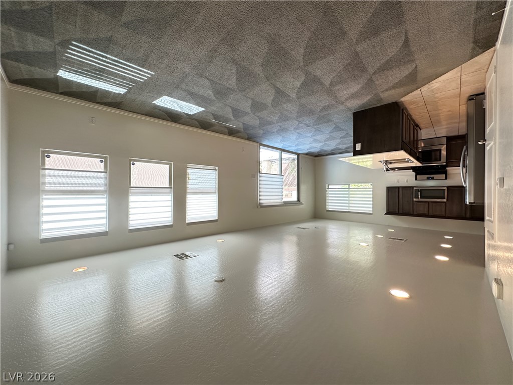 6784 Pivot Point Street Las Vegas, NV 89148 - Photo 4 of 27 A well-lit, open-concept living area seamlessly connects to the kitchen, offering modern comfort.