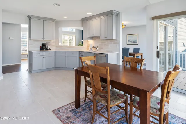 a kitchen with a dining table chairs and refrigerator