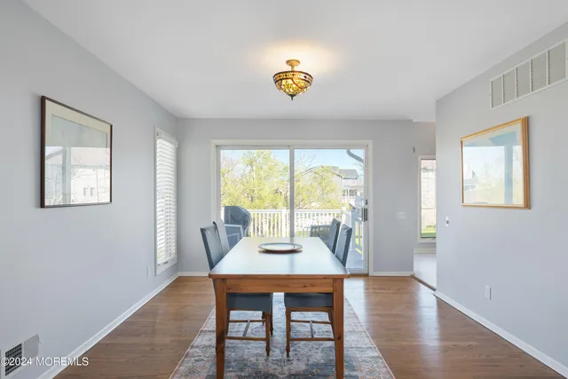 a view of a dining room with furniture a rug and wooden floor