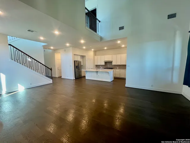 a kitchen with a refrigerator and white cabinets