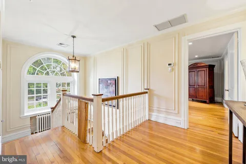 a view of a hallway with wooden floor and windows