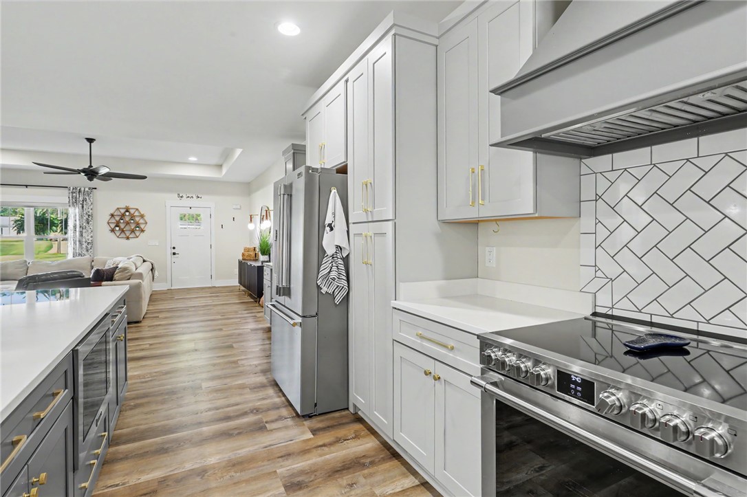 701 Coneross Creek Road Seneca, SC 29678 - Photo 9 of 35 A herringbone tile backsplash adds visual interest behind the range, while abundant cabinetry provides plenty of kitchen storage.